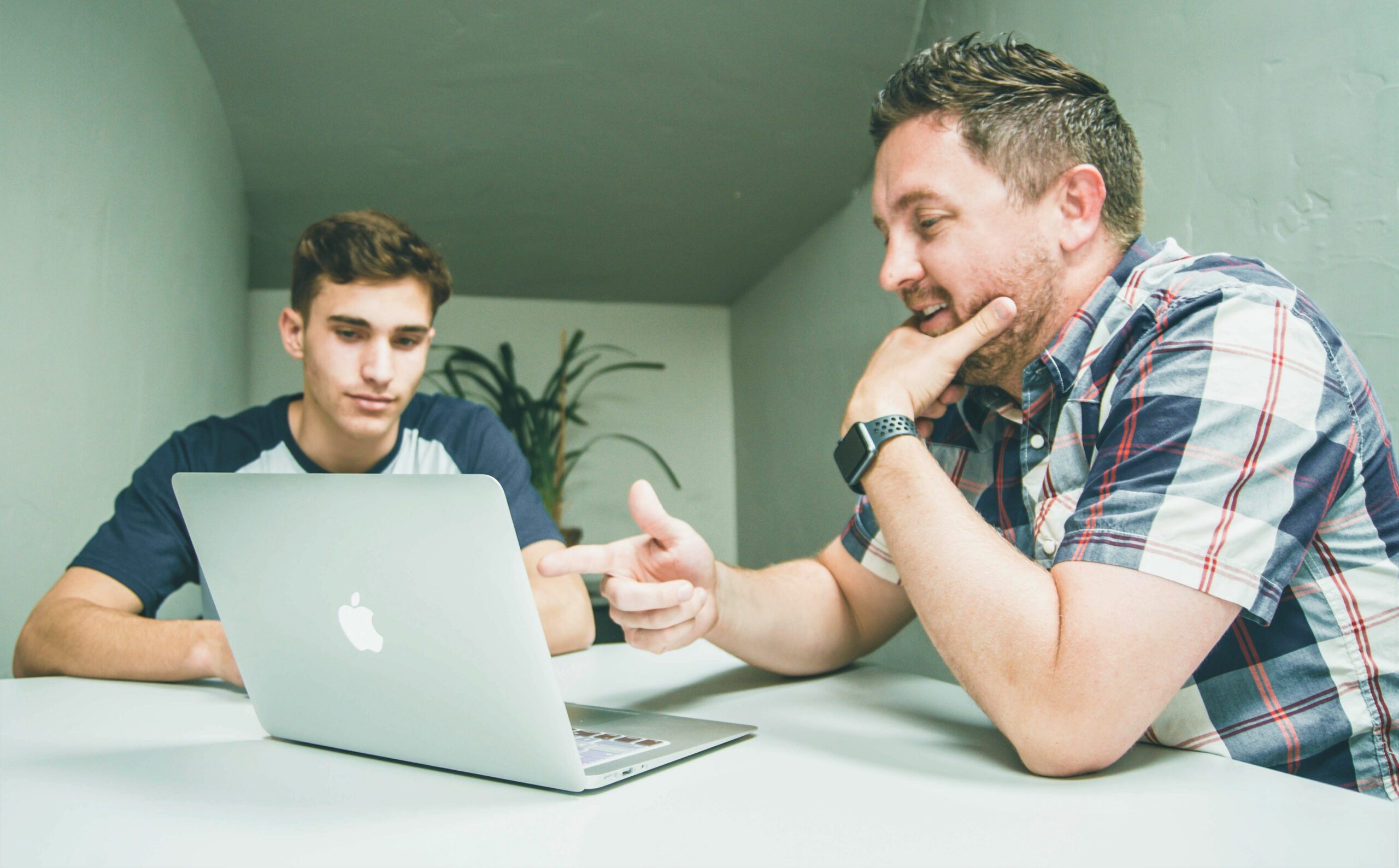 Deux hommes travaillent face à un ordinateur en milieu académique.